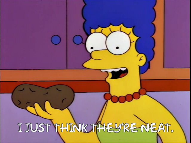 Marge holding a potato, thinking it's neat.