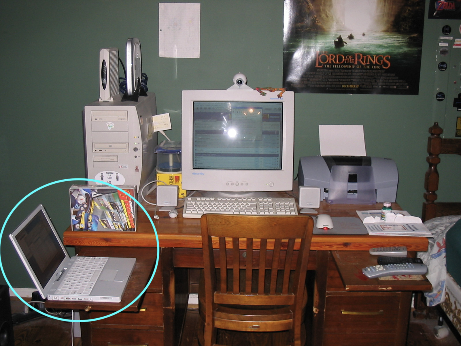 A messy computer desk with a laptop circled in blue.